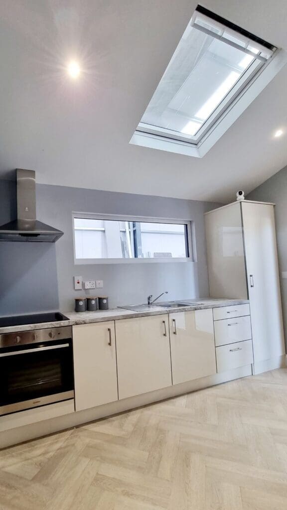 Contemporary kitchen with , stainless steel appliances, and ample natural light inside a Shanette extension